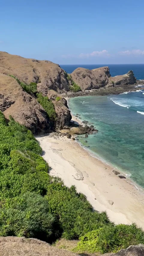 High angle view of sandy beach, ocean and rocks. Stockbeeldmateriaal 340458763