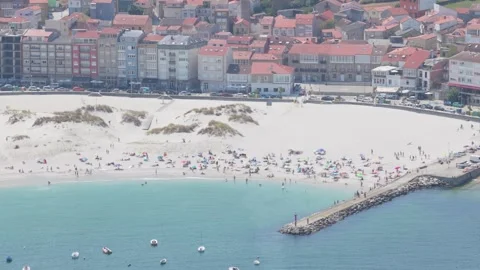 A high-angle view of the sandy beach in Laxe, Galicia, Spain, showing sunbathers Stock Footage 346704781