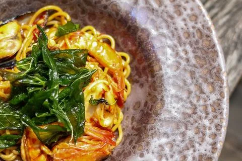High angle view of seafood basil spaghetti served on half a plate Foto stock