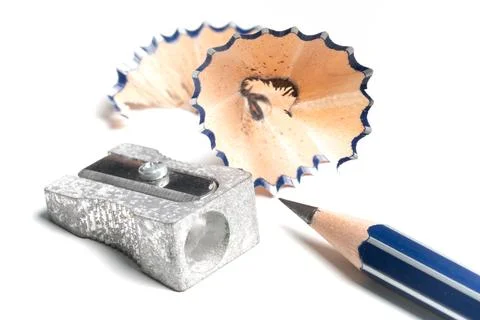 High angle view of sharp pencil, pencil sharpener and shavings on white desk Foto stock