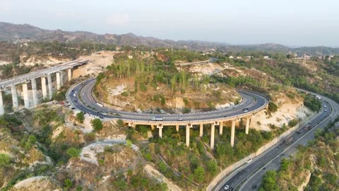 High-angle view of sharp S-curve road and structural pillars at golden hour suns Stockbeeldmateriaal 335195072