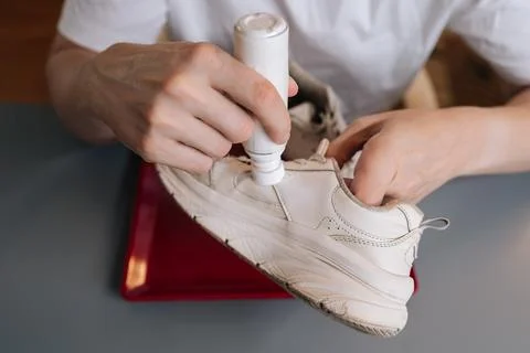 High-angle view of shoemaker using bottle of shoe whitener and painting scuffed Stock Photos