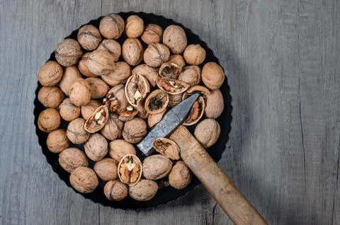 High angle  view   shot of  pan full of whole and cracked   walnuts and a ham Foto stock