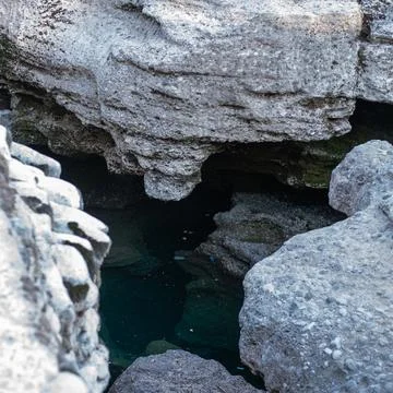 High-angle view shows deep green water pooling inside a narrow rocky canyon Stock Photos