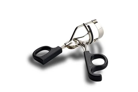 High angle view of single metal eyelash curler with black plastic handles i.. Stock Photos