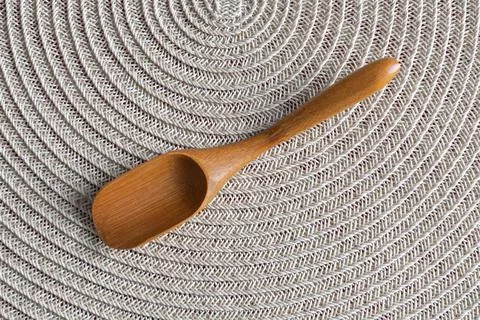 High-angle view of a small handcrafted wooden spoon placed on a round, text.. Stock Photos
