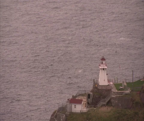 High angle view of small lighthouse overlooking harbor Stock Footage 86699362