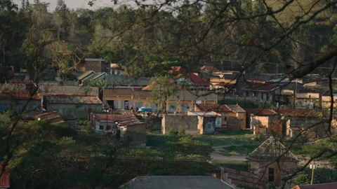 High angle view of a small rural town in africa surrounded by lush green trees Stock Footage 337200359