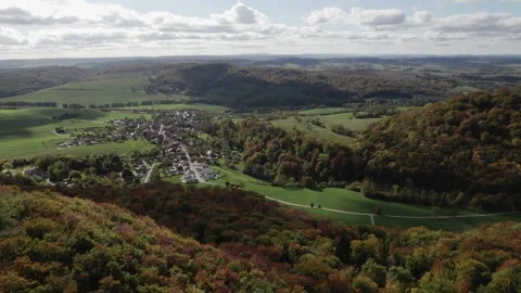 High angle view of small village among rolling autumn hills, patchwork Stock Footage 343307996
