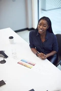 High Angle View Of Smiling African American Businesswoman Sitting At Table In Stock Photos