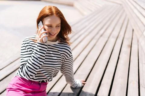 High-angle view of smiling redhead female hipster talking by mobile phone Stock Photos