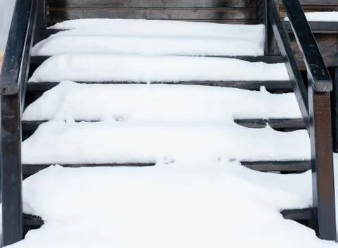 High angle view of snow covered brown wooden stairs during winter Stock Photos