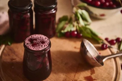 High angle view of spilled poured freshly made cherry jam in sterilized glass Stock Photos