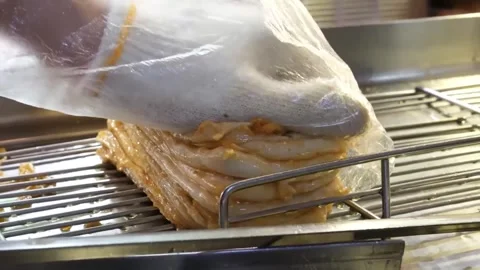 High-Angle View of a Stack of Freshly Prepared Korean Fish Cakes on a Metal Grid Stock Footage 337374870