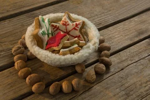 High angle view of star shape cookies in bowl amidst walnuts Fotos de archivo