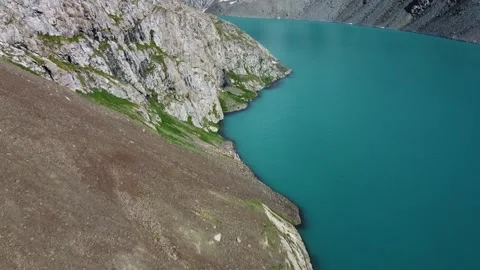 High angle view of steep rocky shore and turquoise alpine lake water, minimalist 库存影片 334326506