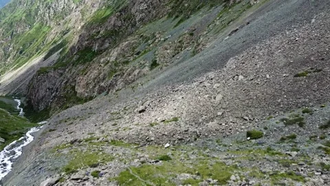 High angle view of steep rocky scree slope and winding mountain river in gorge Stock Footage 335093544