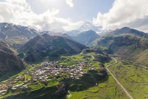 High angle view of Stepantsminda surrounded by the great Caucasus mountains in Stock Photos