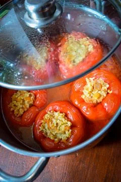 High angle view of stuffed red bell peppers cooking in a pot with savory sauce Stock Photos