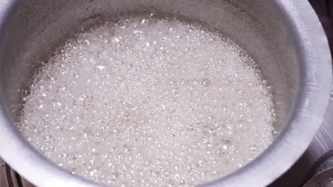 High angle view of sugar syrup boiling with white foam bubbles Stock Footage 346117895