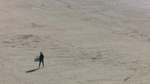 High angle view of surfer walking on sandy beach with surfboard Stock Footage 334188982