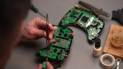 High-angle view of technician using tweezers and soldering iron repairing Stock Footage 302565715