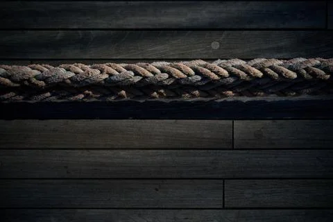 High angle view of a thick braided rope laid horizontally across a wooden shi Stock Photos