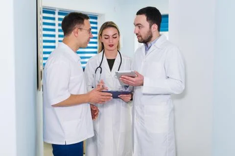 High angle view of three doctors in white coats having conversation at hospital Stock Photos