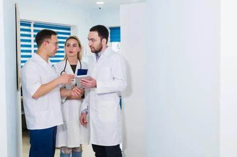 High angle view of three doctors in white coats having conversation at hospital Stock Photos