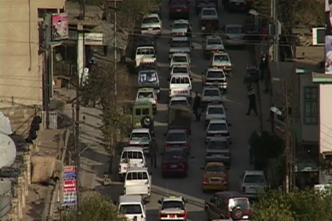 High angle view of three lanes of slow moving traffic down narrow street. Stock Footage 86753577