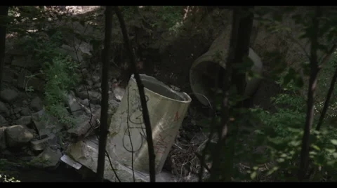 High angle view through trees of rocky stream where sewage water ends Vidéo 57307787