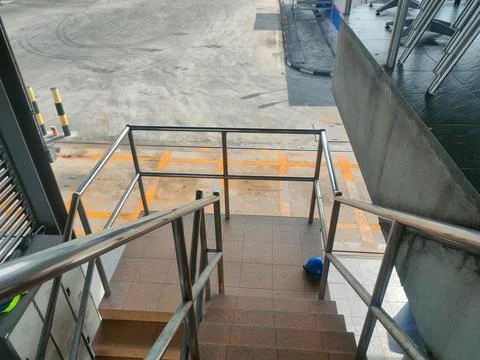 High-angle view of tiled outdoor stairs with stainless steel handrails over.. Stock Photos