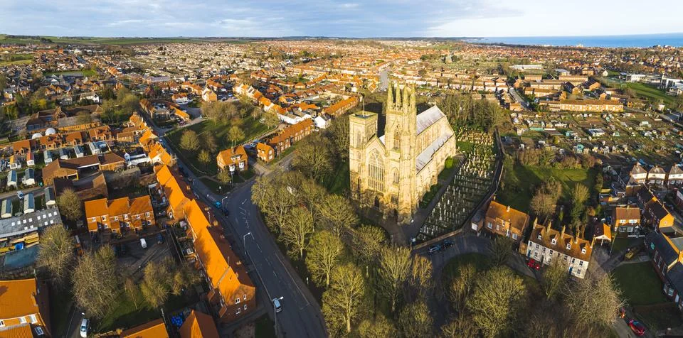 High-angle view of tiny houses with orange roofs and a church in Bridlington Stock Photos