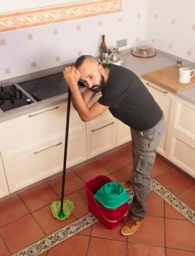 High angle view of a tired young hispanic man mopping the floor Stock Photos