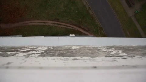 High angle view from top of building showing weathered concrete ledge with Vídeos de archivo 328816366