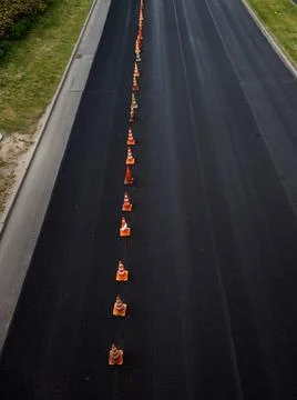 High angle view of traffic cones dividing newly paved asphalt road. Stock Photos