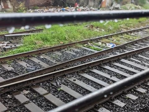 A high-angle view of a train track covered in grass and litter. Stock Photos