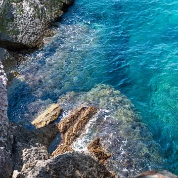 High-angle view of transparent turquoise sea water on rocky shoreline 库存照片