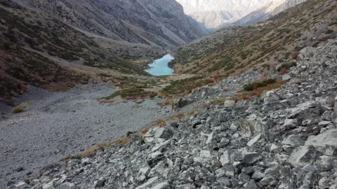 High angle view of turquoise mountain lake at bottom of rocky gorge, autumn Vidéo 334326792