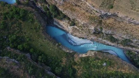 High angle view of turquoise river winding through deep rocky gorge with trees 库存影片 334324313