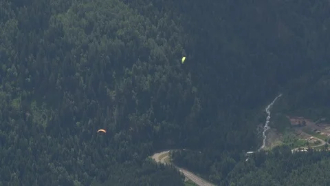 High angle view of two paragliders over mountain highway Stock Footage 124393313
