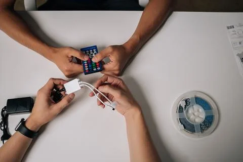 High-angle view of two technicians connecting RGB led strip lights using remote Stock Photos
