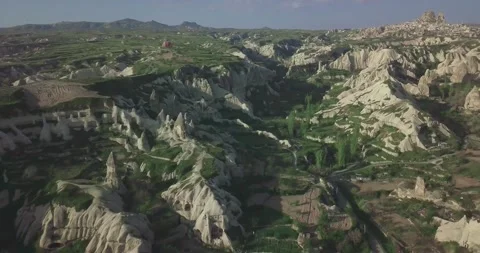 High Angle View of Unique Anatolian Nature Reserve with Distant Hot Air Balloons Stock Footage 340304758
