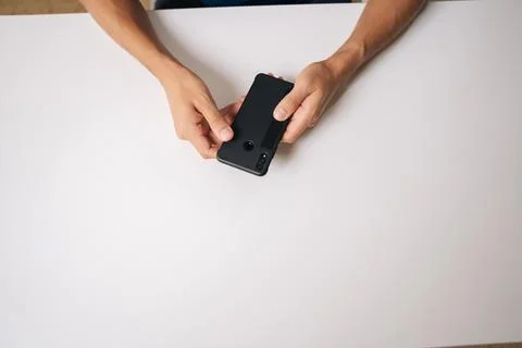 High-angle view of unrecognizable man inserting smartphone into protective case Stock Photos