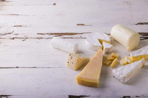 High angle view of various cheese on white wooden table, copy space Stock Photos