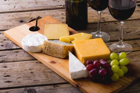 High angle view of various cheese with grapes and red wine on table, copy space Stock Photos