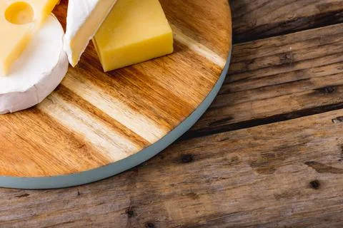 High angle view of various cheese on wooden board at table, copy space Stock Photos