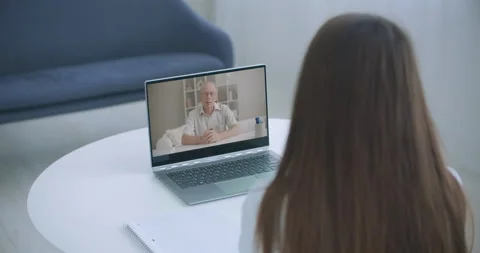 High angle view of video conference with teacher on laptop at home. Girl in Stock Footage 139807215