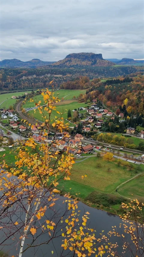 High angle view of village and river valley framed by autumn yellow birch leaves Stock Footage 345555099