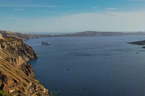 High angle view of volcanic caldera cliffs and passenger cruise ship sailin.. 库存照片
